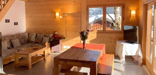 a living room with a couch and a table at Chalet accueillant avec vue sur la montagne - 180 m² - Valmorel in Les Avanchers