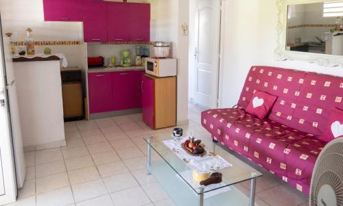 a living room with a purple couch and a table at Appartement douillet avec vue sur les montagnes au Vauclin in Le Vauclin