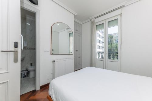 a white bedroom with a bed and a bathroom at Hostal Costa Coruña in A Coruña