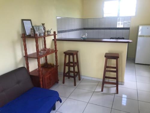 a kitchen with a counter and two bar stools at Appartement avec vue sur la mer à Le Marin, Climatisé, 80 m² in Le Marin