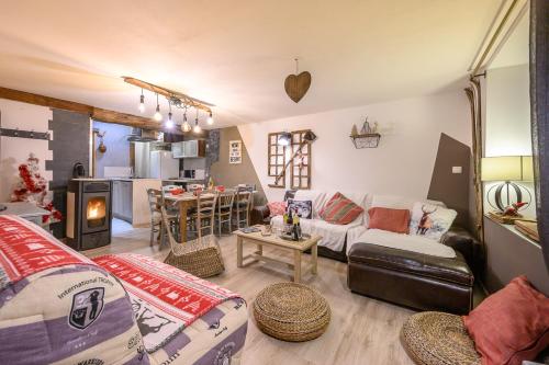 a living room with a couch and a table at Appartement spacieux à Orcières – Vue sur la montagne. in Orcières