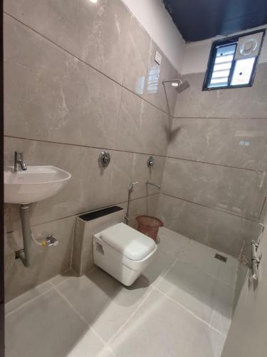 a bathroom with a toilet and a sink at Hotel Pride in Wardha