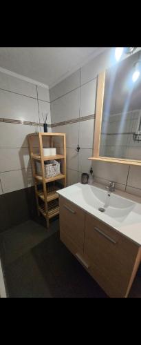 a bathroom with a sink and a mirror and a shelf at Spacious stay in Preveza