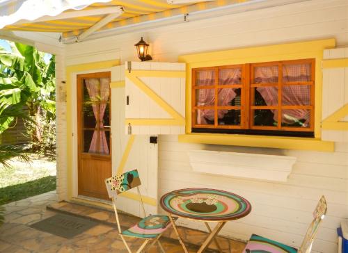 a tiny house with a table and chairs outside at Chalet confortable au Vauclin avec piscine privée in Le Vauclin