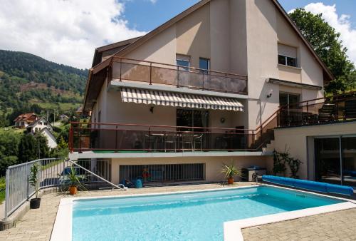 a villa with a swimming pool and a house at Appartement confortable à Oderen 68 m² avec piscine partagée in Oderen