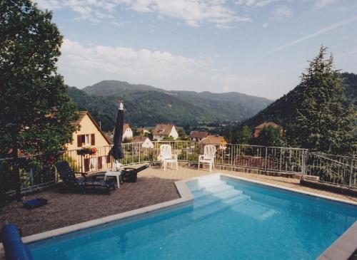 a swimming pool with a view of the mountains at Appartement confortable à Oderen 68 m² avec piscine partagée in Oderen