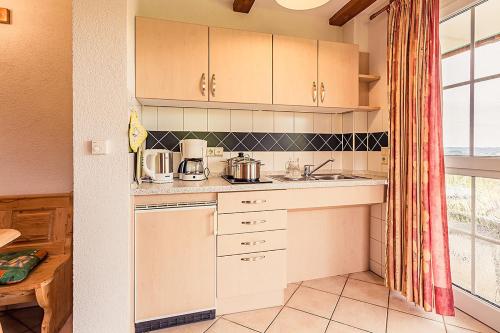 a kitchen with white cabinets and a sink and a window at Dorfstube in Abtsgmünd