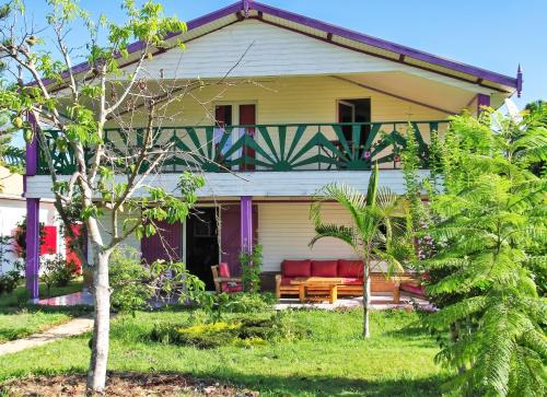 a yellow house with a red couch on the porch at Charming Villa in Foulpointe with Sea View in Foulpointe
