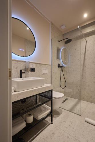 a bathroom with a sink toilet and a mirror at Atlas Aparthotel & Spa in Piatra Neamţ