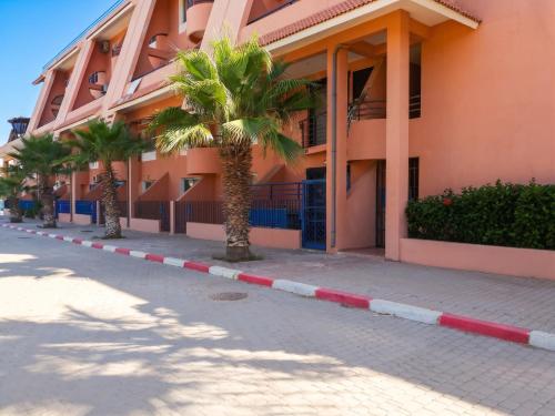 a palm tree in front of a building at Charming Apartment in Imi Ouaddar in Agadir nʼ Aït Sa