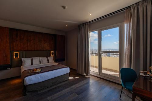 a hotel room with a bed and a large window at Le Louvre Hotel & Spa in Antananarivo