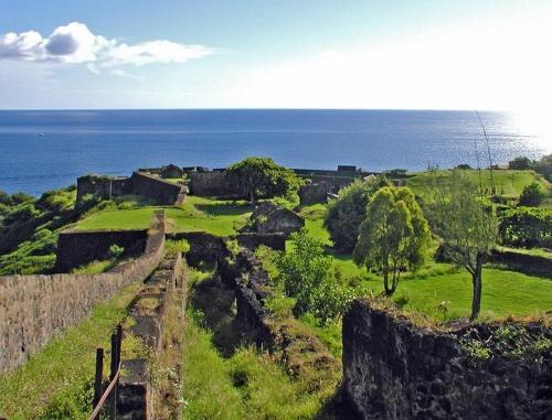 a view of a castle with the ocean in the background at Studio accueillant à Baie Mahault, 22 m², piscine partagée. in Baie-Mahault