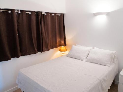 a bedroom with a white bed with a window at Appartement lumineux à Saint-Cyprien 45 m² vue mer in Saint-Cyprien