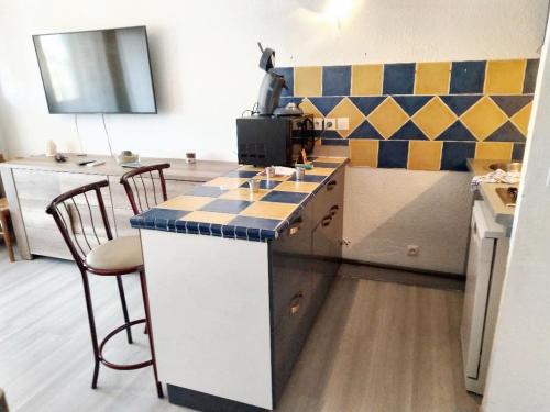 a kitchen with a counter with chairs and a table at Studio charmant à Fréjus avec piscine commune - 30 m² in Fréjus
