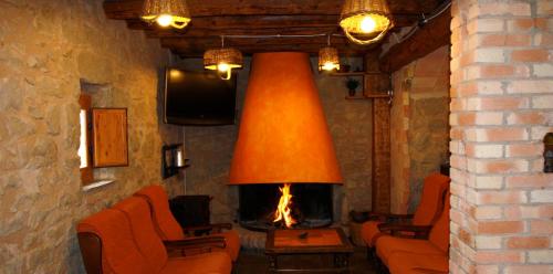 a living room with a fireplace with orange chairs at Charming Villa in Llobera with Private Pool in Llanera