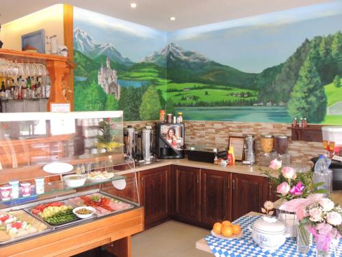 a kitchen with a painting on the wall at Bajor Panzió Bük-Bükfürdő, Adults Friendly 12 Plus in Bük