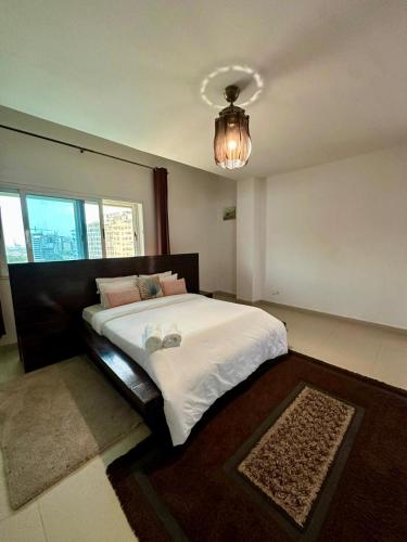 a bedroom with a large bed and a chandelier at Immeuble Mohamet Mbacké TAÏF in Dakar