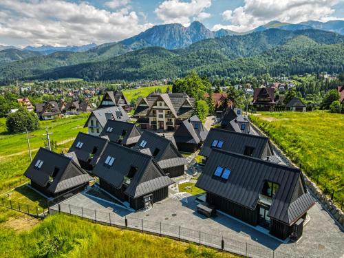 an aerial view of a village with houses and mountains at Crystal Peak Villas z prywatnym jacuzzi, Odkryj-Zakopane in Kościelisko
