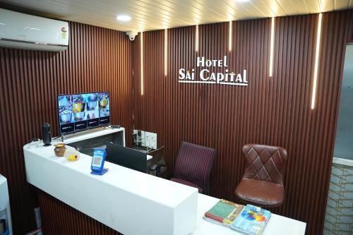 a room with a desk and a tv and a counter at Hotel Sai Capital in Vijayawāda