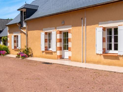 a yellow house with white shutters and a driveway at Maison accueillante à La Chapelle-aux-Choux avec jardin spacieux 70 m² in La Chapelle-aux-Choux