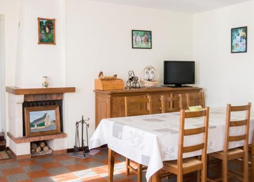 a dining room with a table and a tv and a fireplace at Maison accueillante à La Chapelle-aux-Choux avec jardin spacieux 70 m² in La Chapelle-aux-Choux