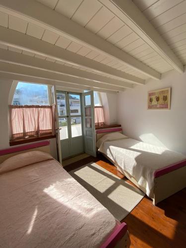 a room with two beds and a window at EnjoyPatmos in Skala