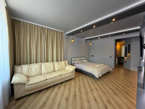 a living room with a couch and a bed at ADAM Apartments Krāslava in Krāslava