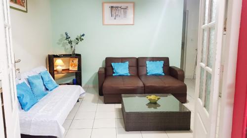 a living room with a couch and a table at Maison confortable Le Moule Jacuzzi in Le Moule