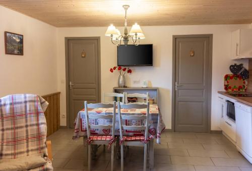 a kitchen with a table with chairs and a tv at Appartement confortable à Cornimont 30 m² vue montagne in Cornimont