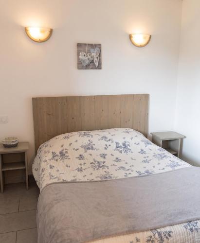 a bed with a wooden headboard and two tables at Appartement confortable à Cornimont 30 m² vue montagne in Cornimont