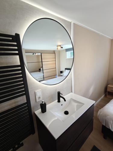 a bathroom with a sink and a mirror at Luxe 6 persoons bungalow met 3 slaapkamers 2 badkamers en ensuite ligbad in Sint Maartensvlotbrug