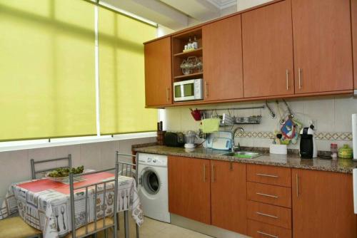 a kitchen with a sink and a washing machine at Comfortable apartment with lake view in Vila Real - 75m² in Vila Real de Santo António