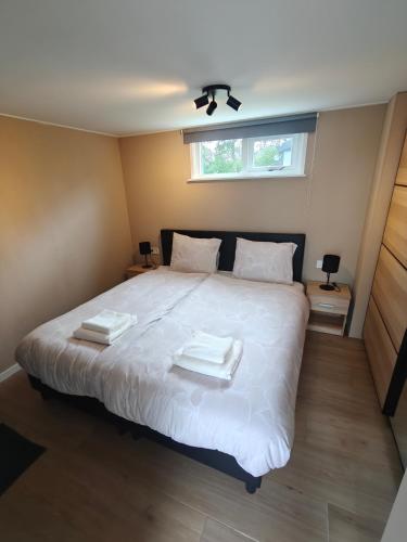 a bedroom with a bed with two towels on it at Luxe 6 persoons bungalow met 3 slaapkamers 2 badkamers en ensuite ligbad in Sint Maartensvlotbrug