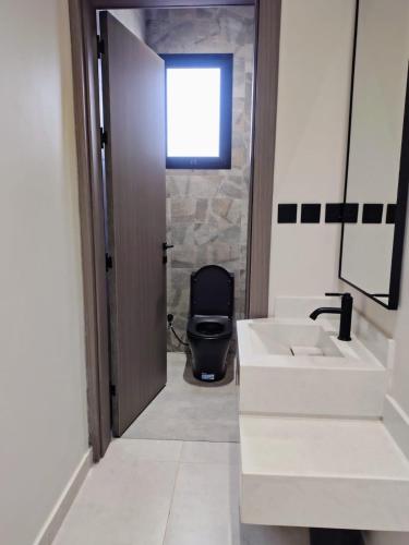 a bathroom with a toilet and a white sink at شاليهات ترف in Abha