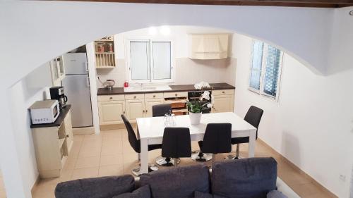 a kitchen and dining room with a table and chairs at Villa enchanteresse à Saint-Benoît avec piscine privée in Saint-Benoît