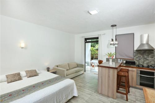 a bedroom with a bed and a desk and a kitchen at Charming studio in Moka 40 m² with mountain view terrace in Moka