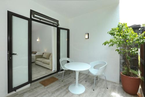 a room with a table and chairs and a couch at Charming studio in Moka 40 m² with mountain view terrace in Moka