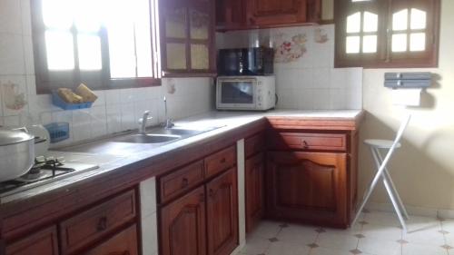 a kitchen with a sink and a microwave at Appartement panoramique Bouillante in Bouillante
