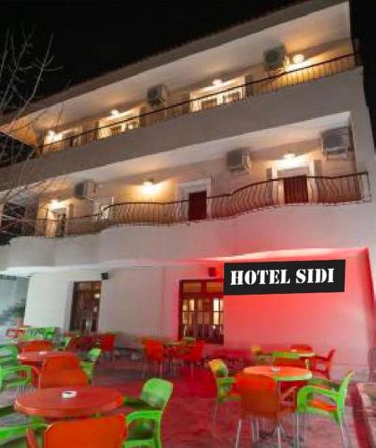 a hotel with tables and chairs in front of a building at Hotel Sidi in Tirana
