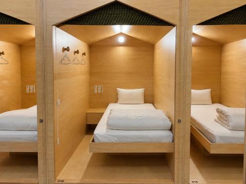 two beds in a small room with mirrors at 女性専用 Woman Only capsule MAJA HOTEL KYOTO マヤホテルキョウト in Kyoto