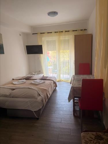 a bedroom with a bed and a table and a window at Adrasteja 3 - apartment Dramalj in Dramalj