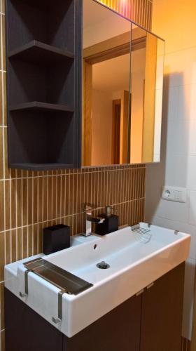 a bathroom with a white sink and a mirror at Apartamento Estrella Rural in Lumpiaque