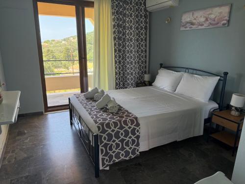 a bedroom with a bed and a large window at Loukia's apartment no 2 in Mesochórion