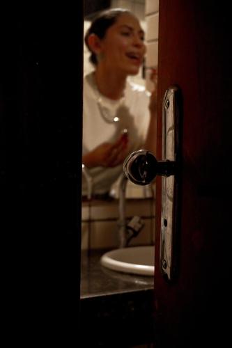 a woman standing in a bathroom with a sink at Hotel Tupinambá Timon in Timon