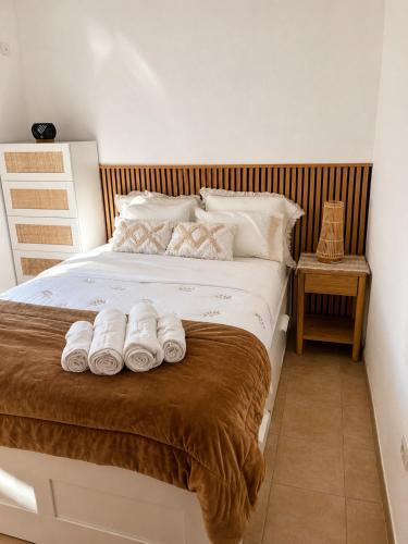 a bedroom with a bed with towels on it at Casa da Maré in Calheta