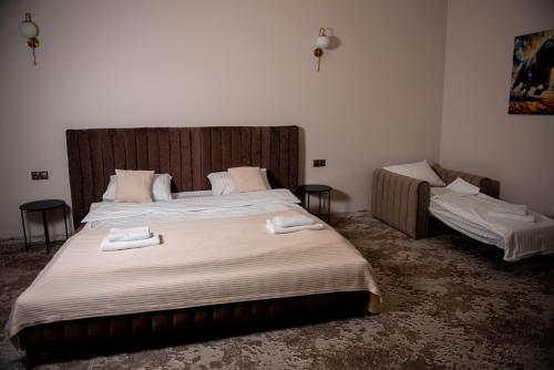 a bedroom with a large bed with two tables and two beds sidx sidx at Hotel Taurus in Solotvyno