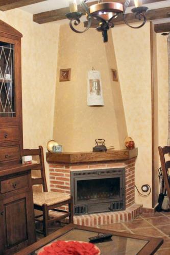 a living room with a fireplace and a chandelier at Family Apartment with Mountain View in Hueva in Hueva