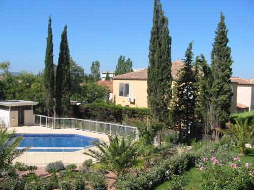 a villa with a swimming pool and trees at Appartement avec terrasse à Fréjus, 70 m², piscine partagée in Fréjus