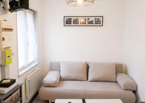 a couch in a living room with a window at Studio cosy à Montargis - 13 m² - Parking inclus in Montargis