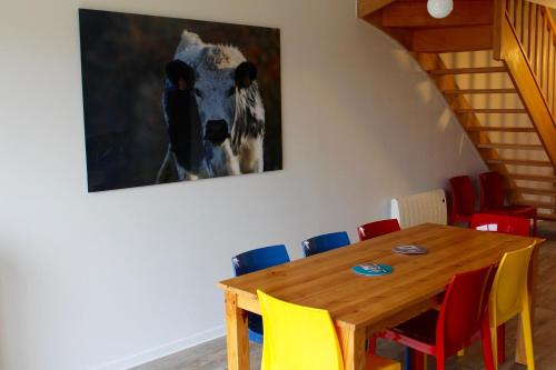 a dining room with a wooden table and colorful chairs at Appartement accueillant à Xonrupt-Longemer 70 m² avec jardin privatif in Xonrupt-Longemer